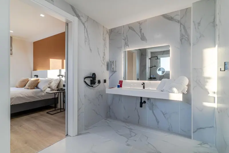 Une salle de bain moderne avec un grand miroir et un lavabo surélevé.
