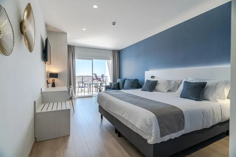 Une chambre lumineuse avec un grand lit et un accès à une terrasse.