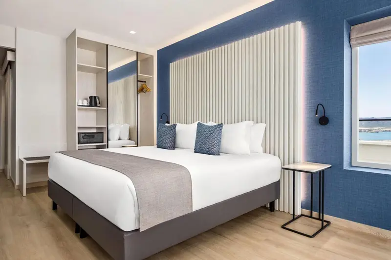 Une chambre d'hôtel moderne avec un grand lit et une décoration sobre.
