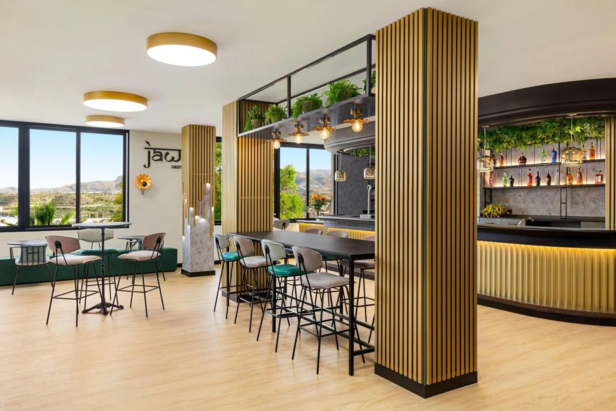 Une salle lumineuse avec un comptoir de bar et des tables.