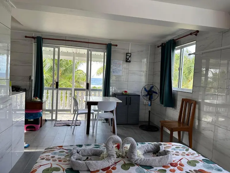 Une chambre lumineuse avec un espace repas donnant sur une vue tropicale.