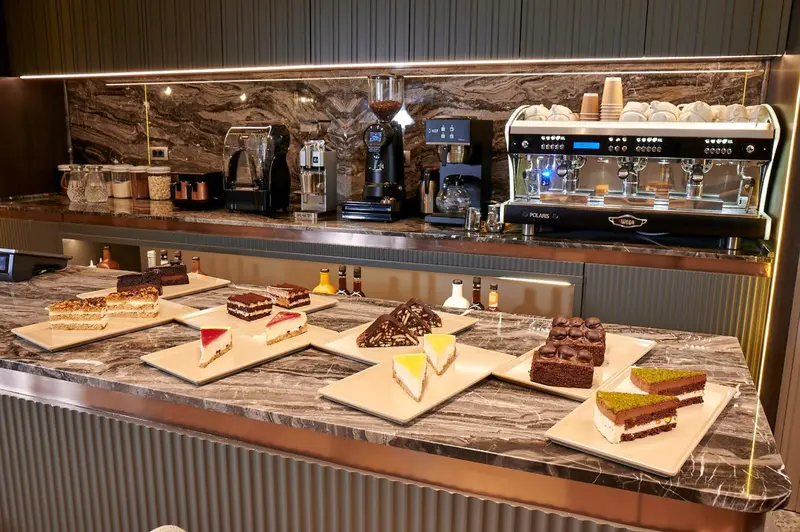 Un comptoir présente des pâtisseries et des boissons chaudes.
