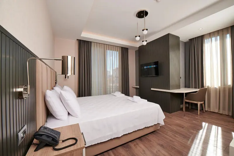 Une chambre lumineuse avec un grand lit et un bureau.