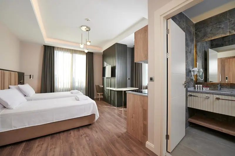 Une chambre lumineuse avec un lit double et un espace cuisine.