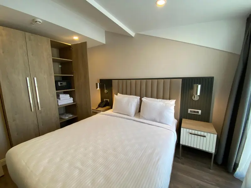 Une chambre avec un grand lit et un placard intégré.