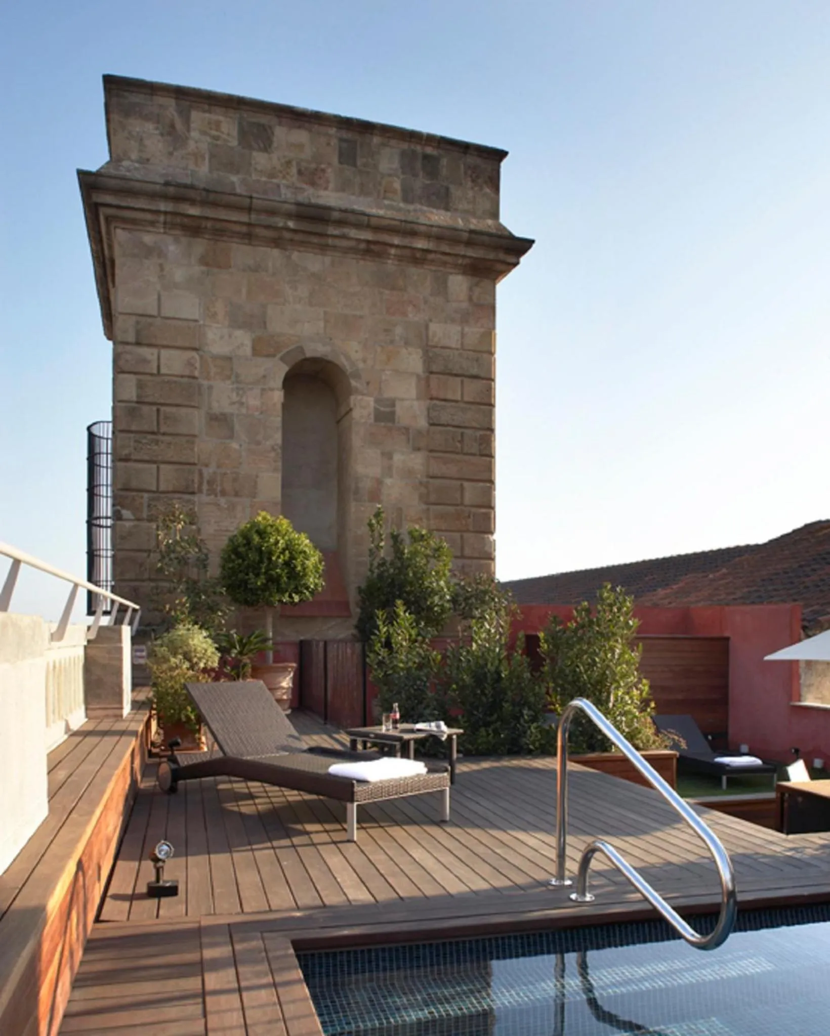 Terrasse avec piscine et mobilier de détente.