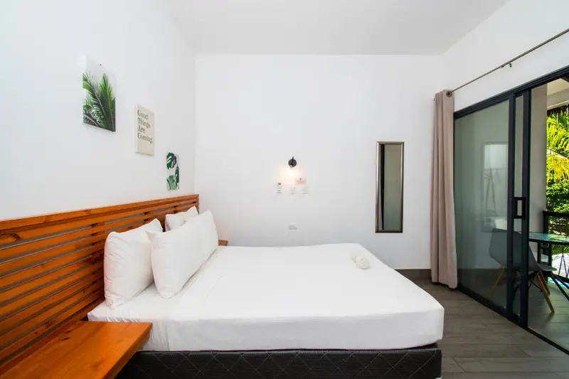 Une chambre lumineuse avec un grand lit et un accès à une terrasse.