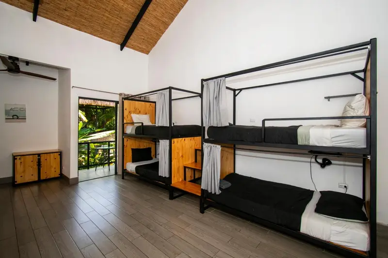 Une chambre avec plusieurs lits superposés en bois et métal.