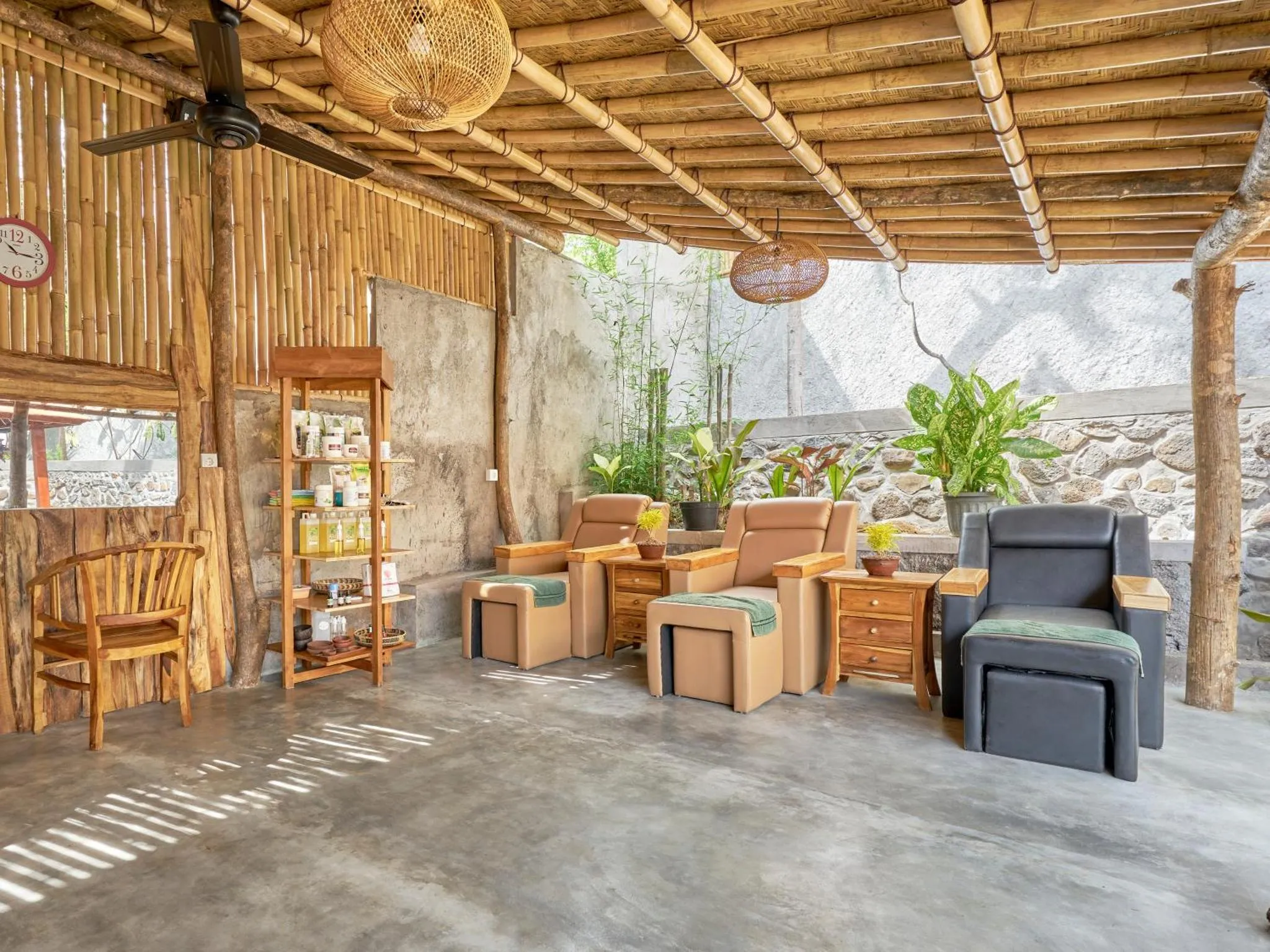 Espace de détente ombragé avec mobilier en bois et végétation tropicale.