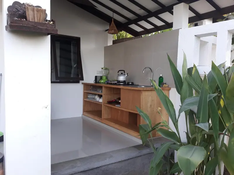 Cuisine extérieure avec plan de travail en bois et évier.