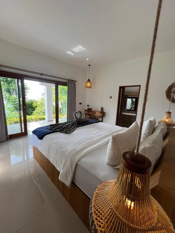 Une chambre lumineuse avec un grand lit et un accès à une terrasse.