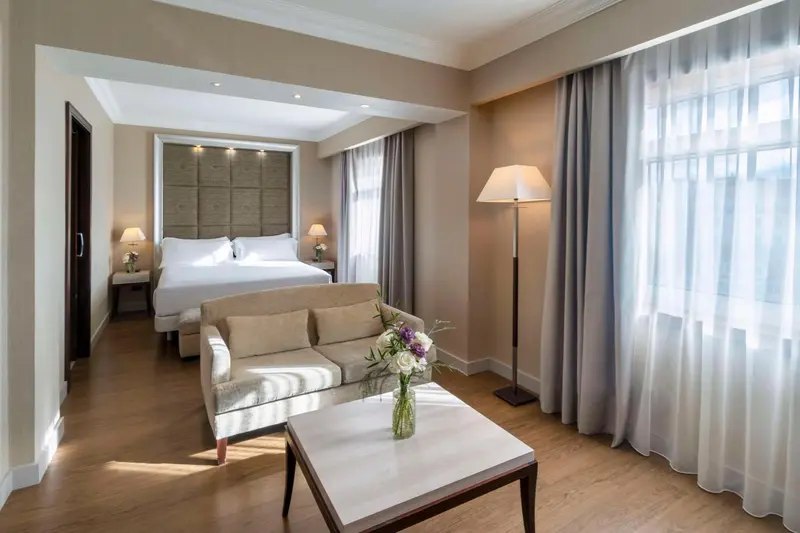 Une chambre lumineuse avec un canapé et un grand lit.