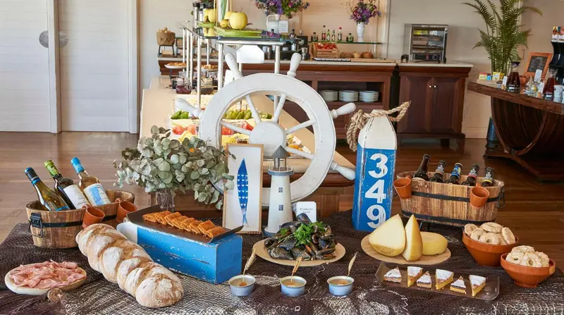 Un buffet propose des mets variés et des boissons sur un présentoir décoré sur le thème de la mer.