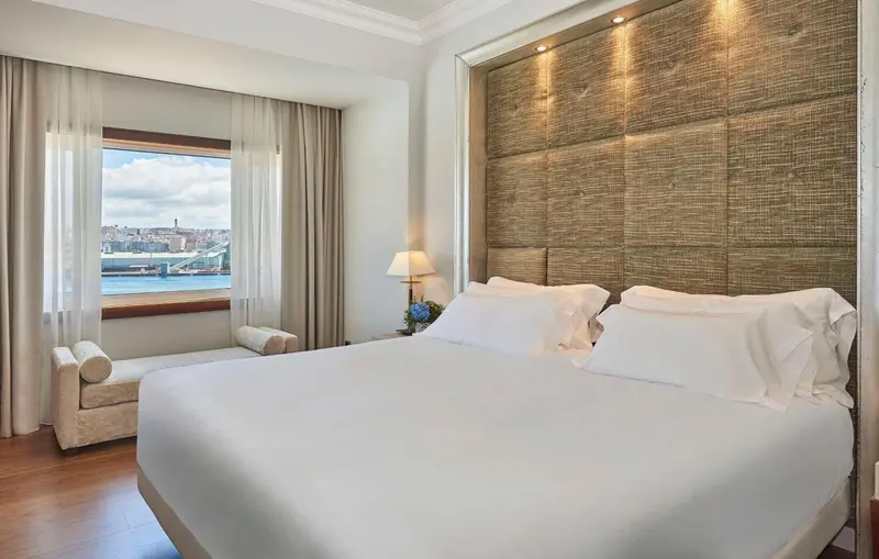 Une chambre lumineuse avec un grand lit et une vue sur la mer.