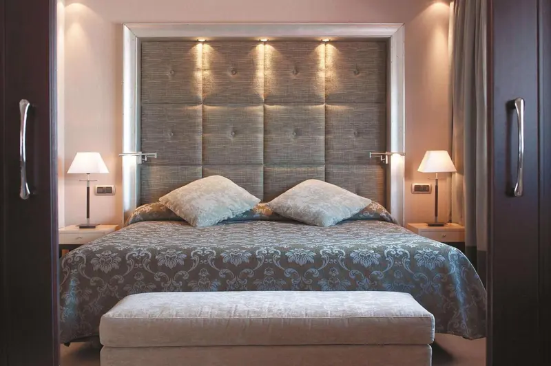 Une chambre à coucher avec un grand lit et une décoration sobre.