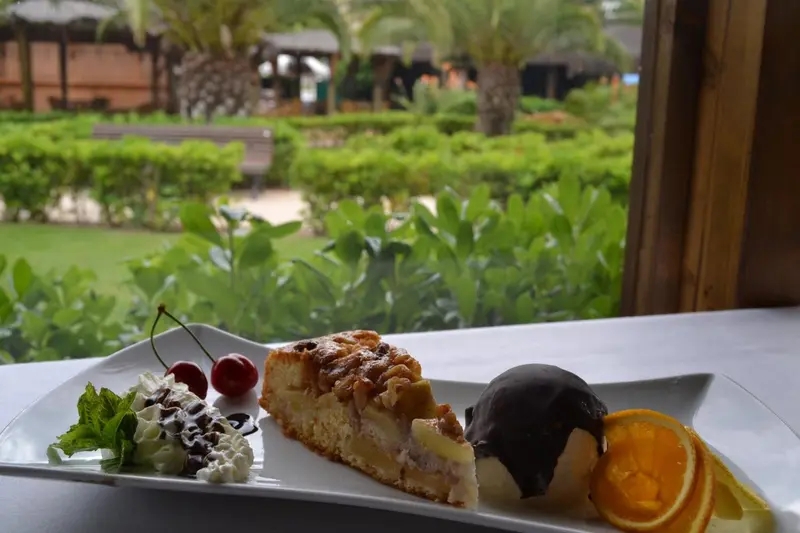 Une part de gâteau aux cerises et une boule de glace sont présentées sur une table.