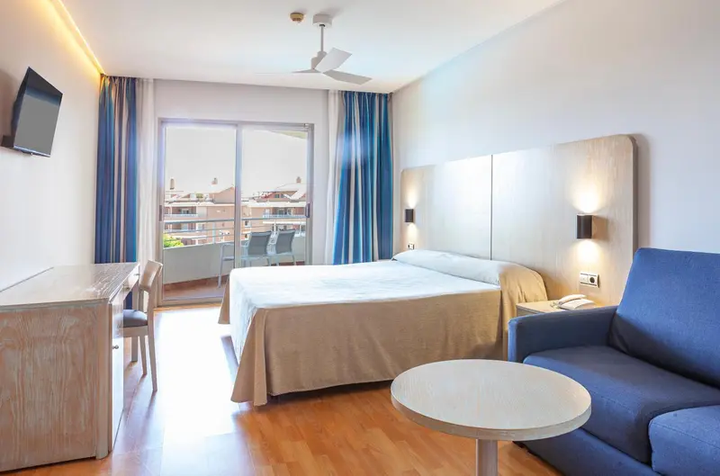 Une chambre lumineuse avec un grand lit et un accès à une terrasse.