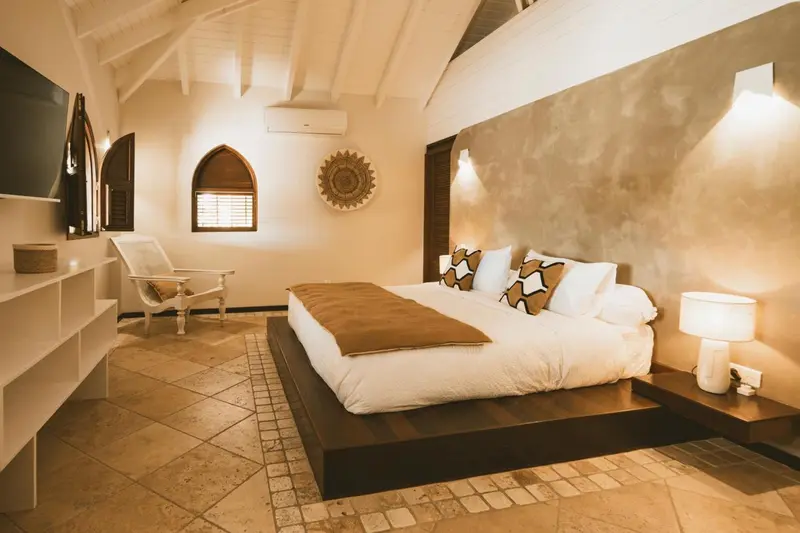 Une chambre lumineuse avec un grand lit et une décoration chaleureuse.