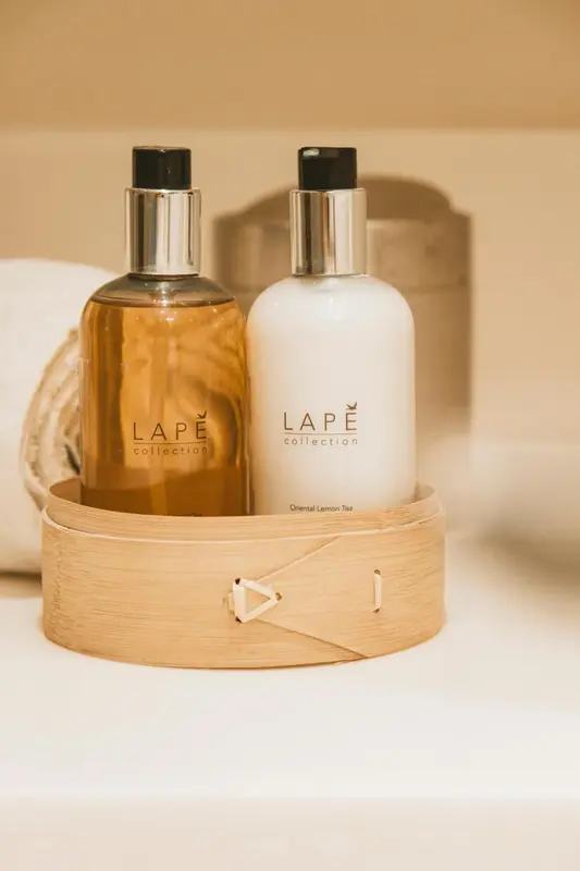 Deux flacons de produits de toilette sur un plateau en bambou.