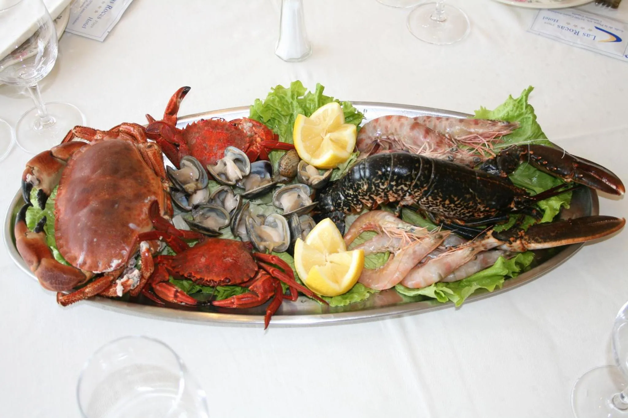 Un plateau de fruits de mer variés est présenté sur une table nappée.
