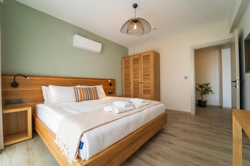 Une chambre lumineuse avec un grand lit et des meubles en bois.