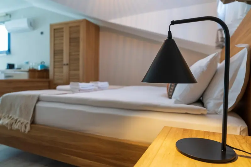 Une chambre lumineuse avec un lit fait et une lampe de chevet.