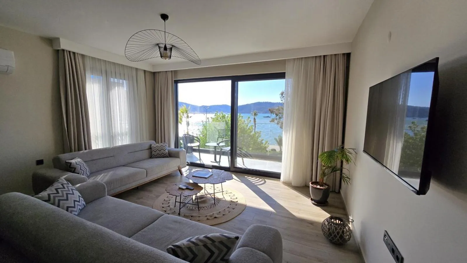 Un salon lumineux s'ouvre sur une terrasse avec vue sur la mer.