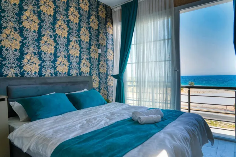 Une chambre avec un grand lit donnant sur la mer.