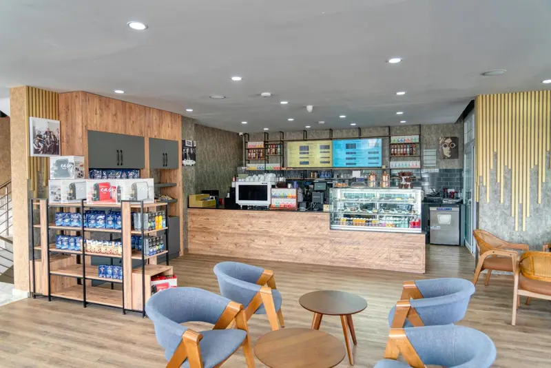 Un espace lumineux avec un comptoir de vente et des tables basses.