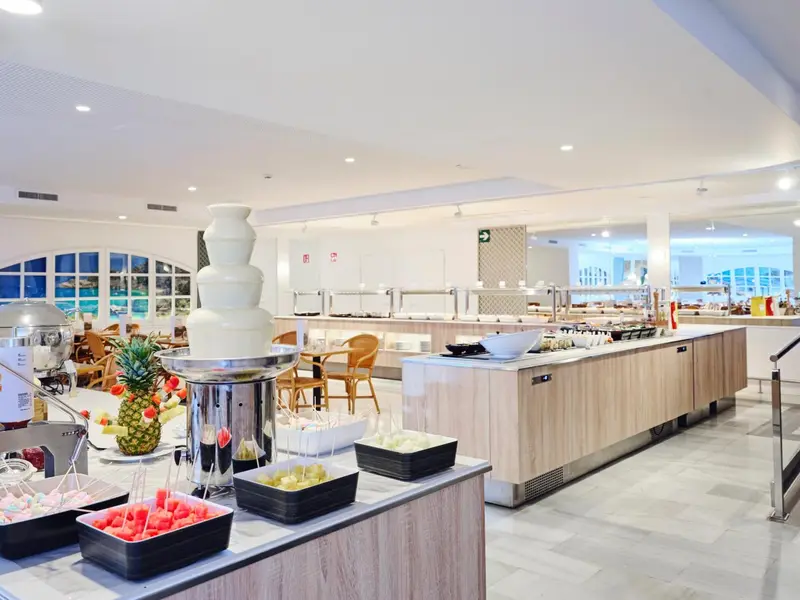 Un buffet propose une variété de plats et de desserts dans une salle lumineuse.