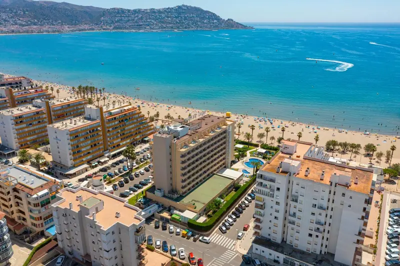 Vue aérienne d'une station balnéaire avec des bâtiments et une plage.