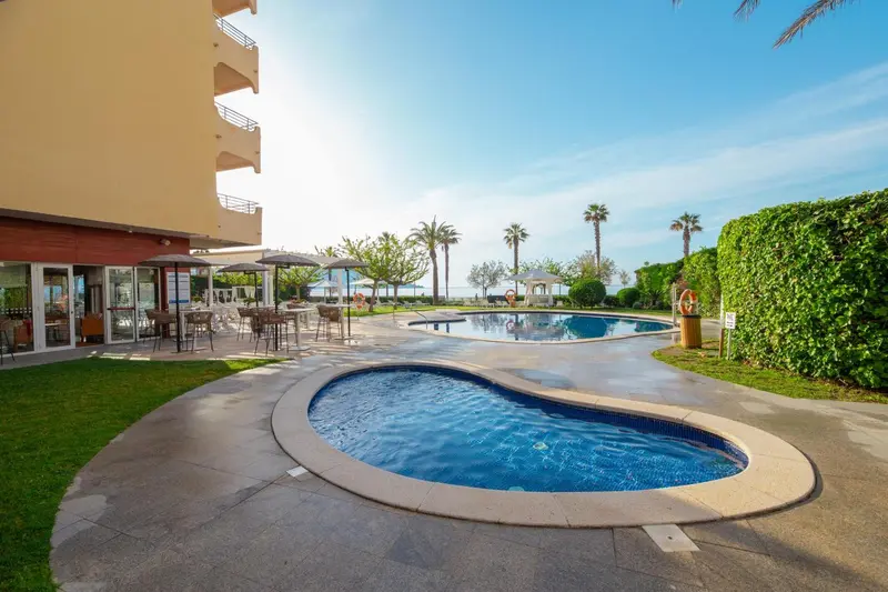 Piscine extérieure avec terrasse et végétation luxuriante.