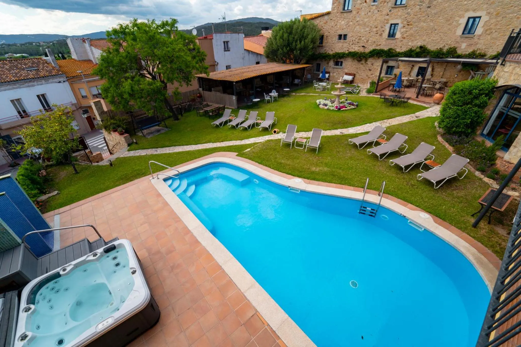 Piscine bleue et transats alignés sur une pelouse verdoyante.