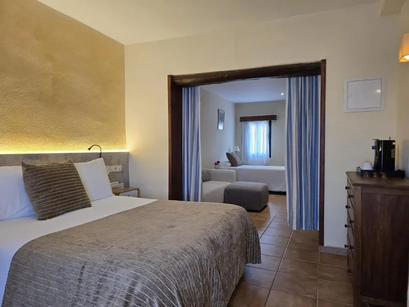 Une chambre avec un lit et un espace salon attenant.