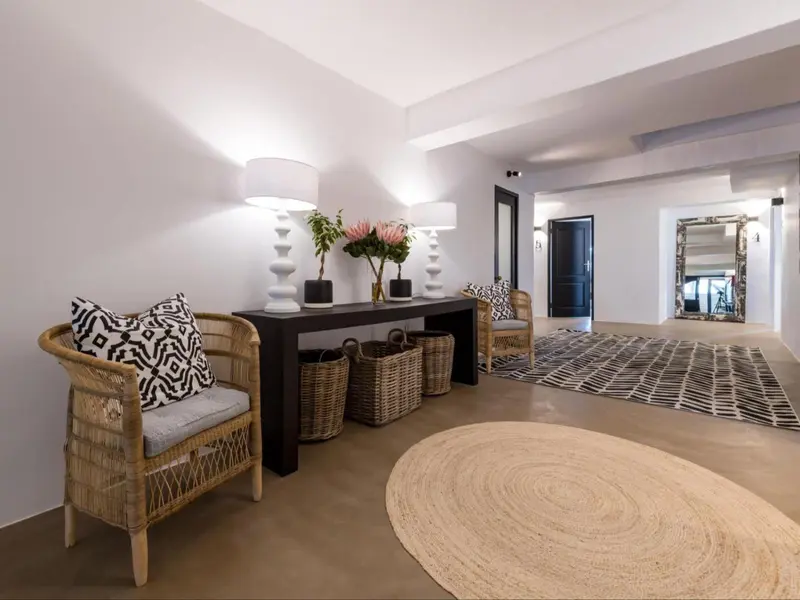 Un espace intérieur clair et minimaliste avec des meubles en rotin et des touches décoratives.