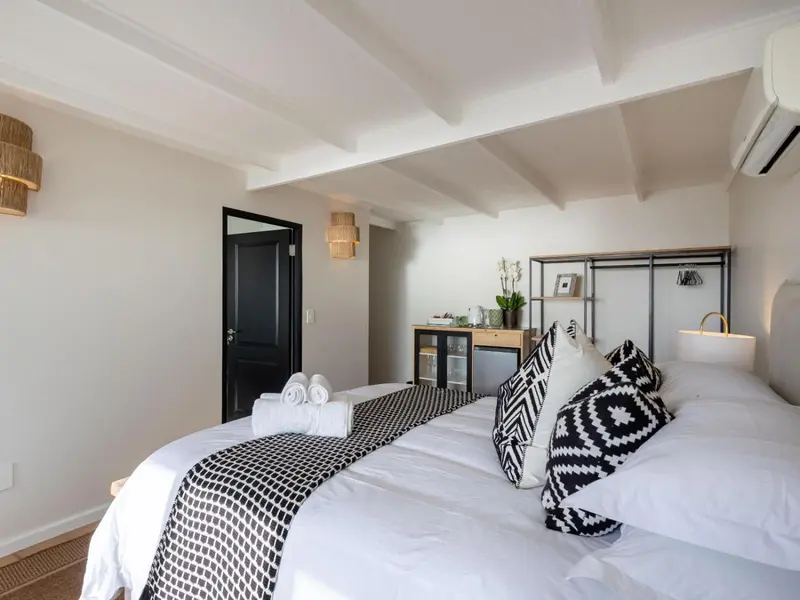 Une chambre lumineuse avec un grand lit recouvert d'une courtepointe graphique.