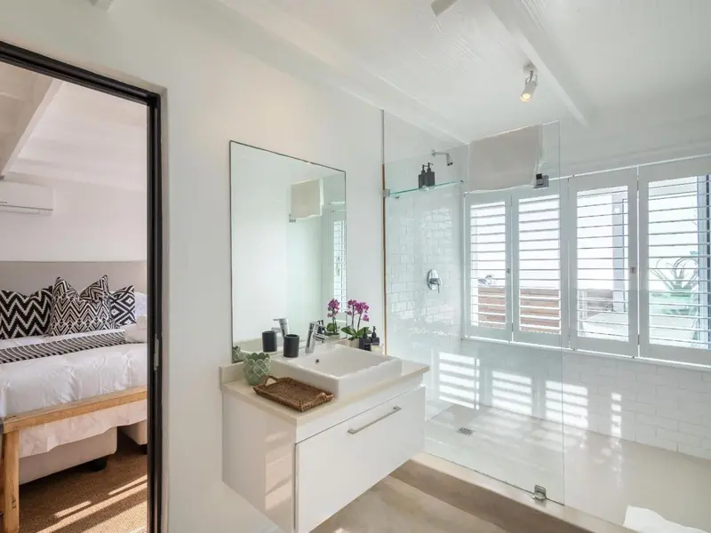 Une salle de bain lumineuse avec douche à l'italienne et lavabo moderne.