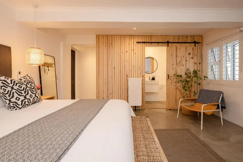 Une chambre lumineuse avec un grand lit et un coin salon.