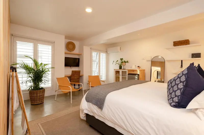 Une chambre lumineuse avec un lit confortable et un coin salon.