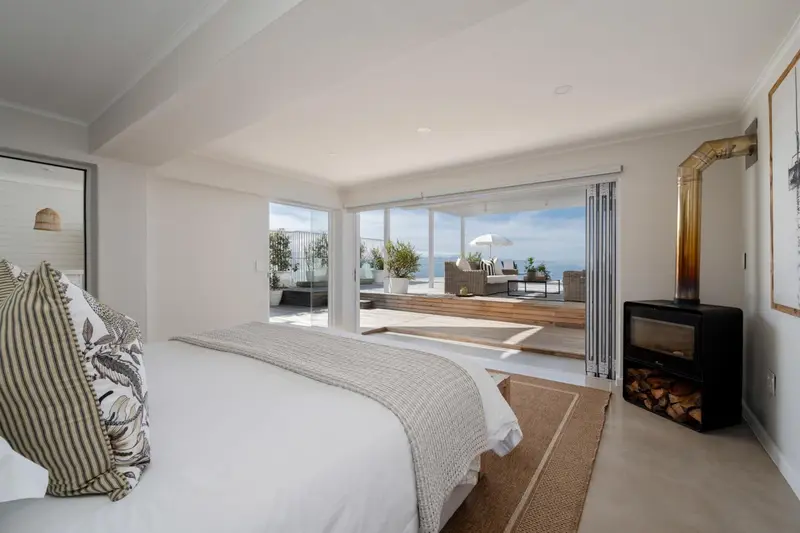 Une chambre lumineuse s'ouvre sur une terrasse avec vue sur la mer.