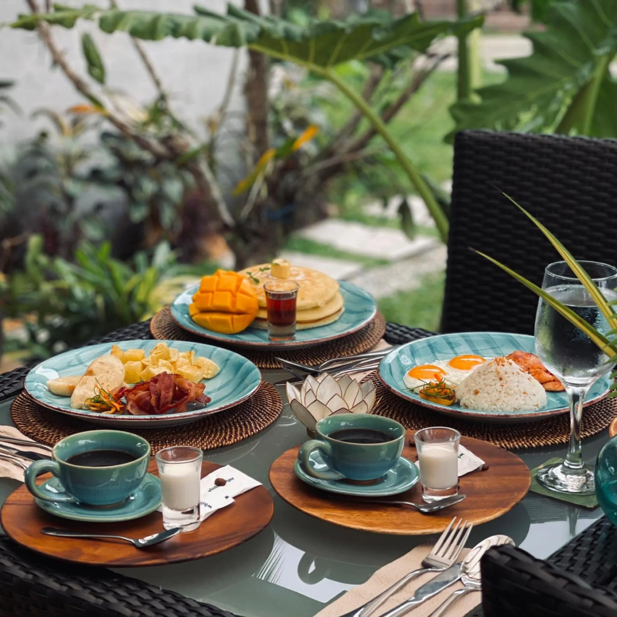 Une table est dressée avec des assiettes de nourriture et des boissons.