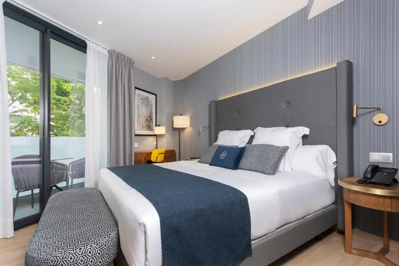 Une chambre d'hôtel moderne avec un grand lit et un accès à un balcon.