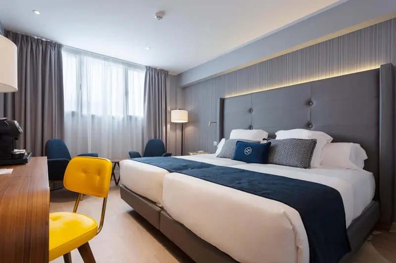 Une chambre d'hôtel moderne avec un grand lit et des fauteuils.