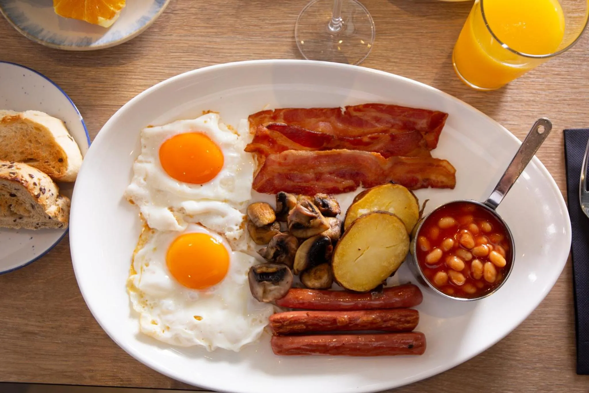 Assiette copieuse avec œufs, bacon, saucisses, haricots et pommes de terre.