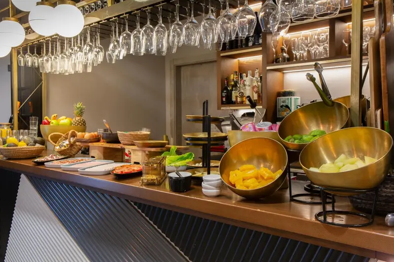 Un comptoir de buffet propose des fruits frais et des pâtisseries.