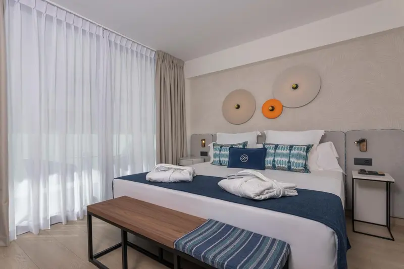 Une chambre lumineuse avec un grand lit et une décoration murale moderne.