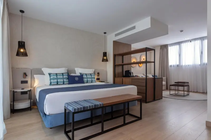 Une chambre lumineuse avec un grand lit et un espace détente.