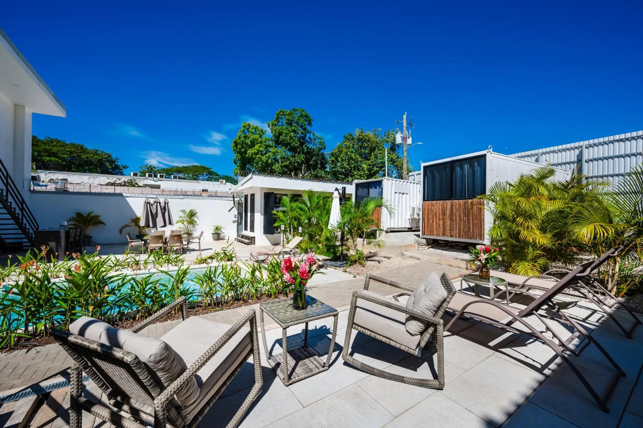Terrasse avec mobilier de jardin et piscine ensoleillée.