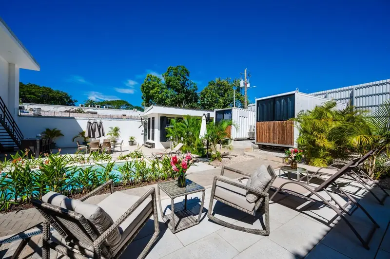 Terrasse avec mobilier de jardin et piscine ensoleillée.