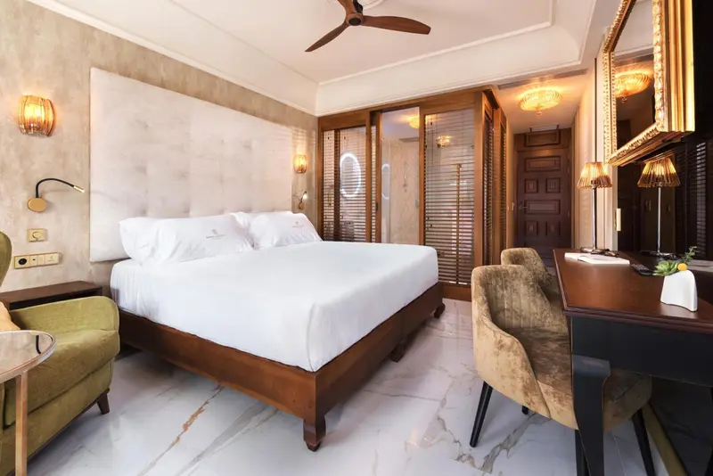 Une chambre lumineuse avec un grand lit et un coin salon.